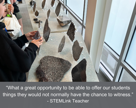 Students examining various rock samples on display; the caption reads, "What a great opportunity to be able to offer our students things they would not normally have the chance to witness -STEMLink Teacher"
