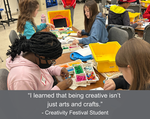 Students working on projects at a table with various crafting materials.