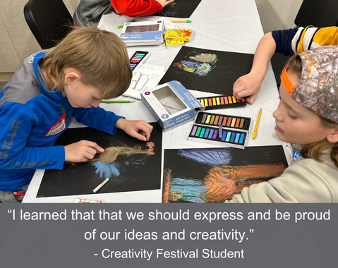 Children drawing colorful pictures on black paper at a table, using pastel crayons.