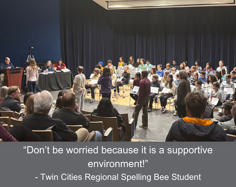 Students sit on stage for a spelling bee while an audience watches; quote encourages a supportive environment.