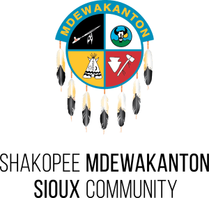 A circular emblem with feathers and the text: Shakopee Mdewakanton Sioux Community.