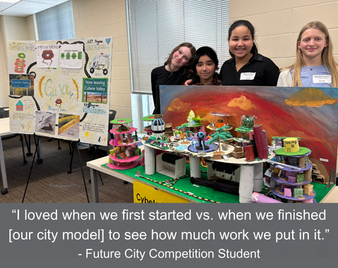 Four students stand behind a colorful city model and poster at the Future City Competition.