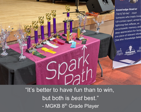 Knowledge Bowl trophies and ribbons on a table with a SparkPath banner